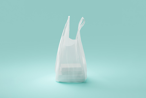 Blank plastic grocery or shopping bag with styrofoam food containers inside on light blue background