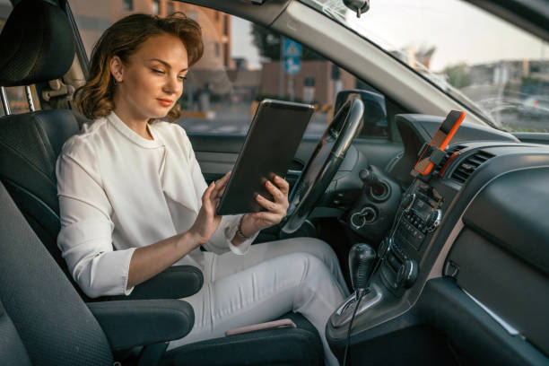istock Driver using digital tablet working online sitting in new comfortable car. Transportation concept 1676050768