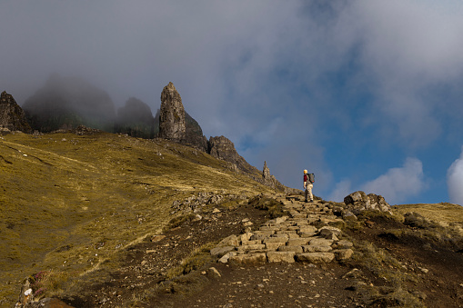 Male hiker enjoying the beautiful countryside landscape of Old man of Storr in the Quiraing of the highlands in Scotland