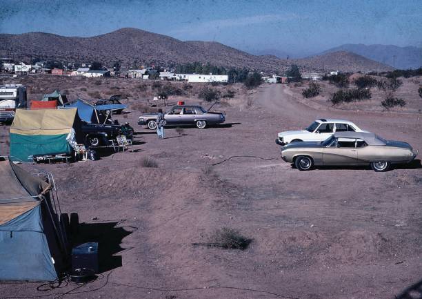 Old Style cars parked in a desert town with tents setup