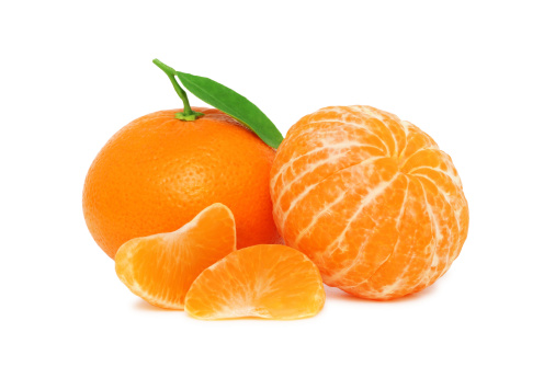 Two ripe mandarins and two slices with green leaves isolated on white background