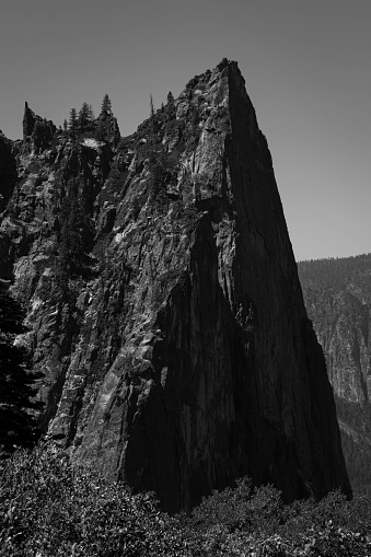 One of the Cathedral Spires as seen from the Four Mile Trail in Yosemite National Park, California. Black and white photo of a mountain of granite.
