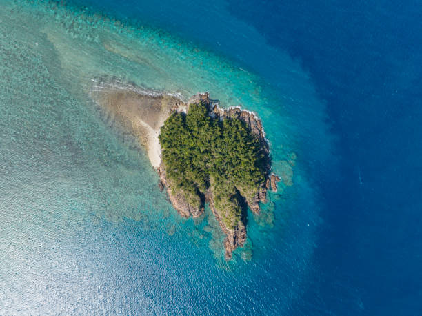High angle aerial drone view of Arkhurst Island, a small islet next to Hayman Island, a luxury resort hotel in the Whitsunday Islands group near the Great Barrier Reef in Queensland, Australia. stock photo