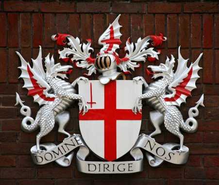 Amsterdam, Netherlands: civic coat of arms of Amsterdam- red shield and a black pale with three silver Saint Andrew's Crosses - shield of Amsterdam on a brick wall.