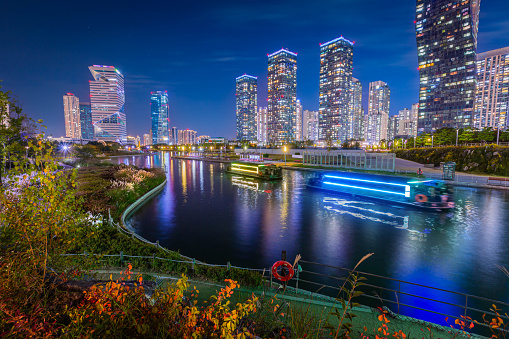 Night view in autumn and beautifully lit tourist boats at Songdo Central Park in Songdo  District, Incheon South Korea.