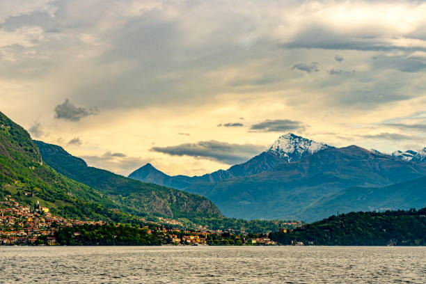 Hillside houses this view is looking towards Bellagio on Lake Como, Lombardy, Italy.  In the background are the Italian Alps with snow covered peaks.