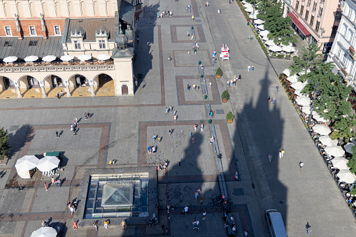 Krakow, Poland - September 9, 2023: Aerial view of the city skyline. Main market square with Cloth Hall (Sukiennice) and shadow of two towers of St. Mary's Church