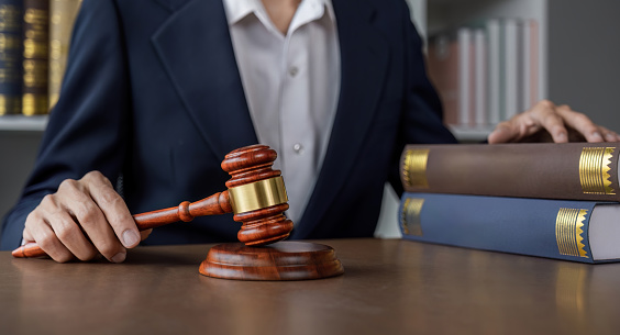 portrait of Male lawyer in office sitting on desk..