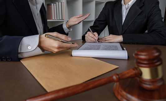 Businessman and lawyer discussing business contract document for legal advice in lawyer's office..