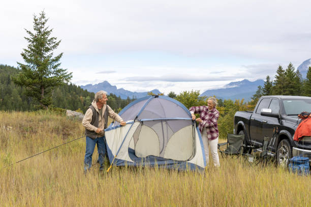 They have parked their vehicle in the meadow and are relaxing in a tent, Crowsnest Pass, Alberta