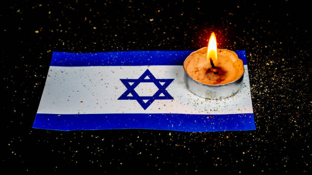istock Israeli flag and candles burning above it, Holocaust memory day 1676124585