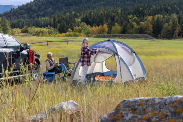 istock Mature couple camp in mountain meadow 1676131073