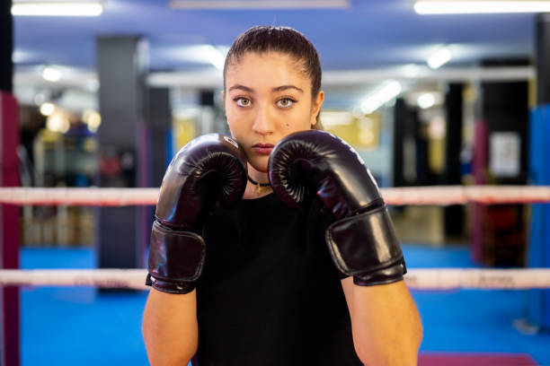 istock Female boxer portrait training with boxing gloves in a ring. 1676133844