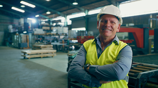 Portrait, happy man and arms crossed in warehouse of industrial engineering, manufacturing logistics or production. Manager, technician and boss smile in factory of supply chain, trade or development