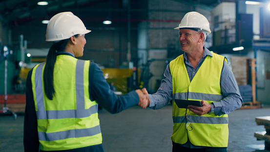 Engineering, handshake and welcome with people in factory for manufacturing, meeting and partnership. Thank you, production and industrial with employees shaking hands in warehouse for agreement