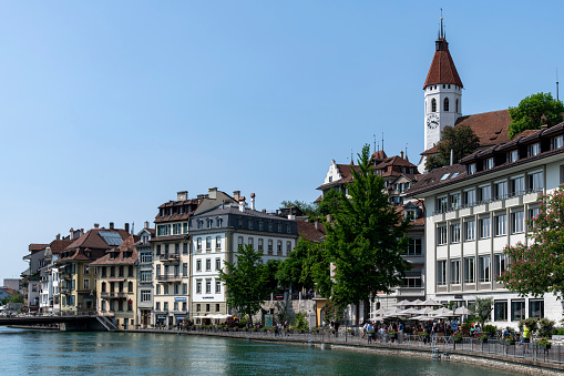 Thun, Switzerland-May 28, 2023; Aare river in the historic downtown district lined with historic houses on the Aarequai or waterfront