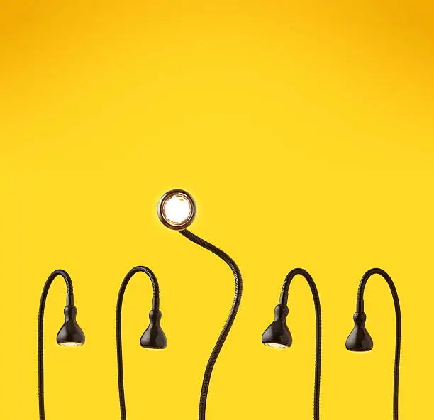 There is five desk lamps on yellow background as characters.