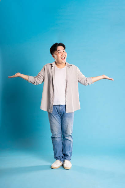istock Full body image of Asian man posing on blue background 1676157900
