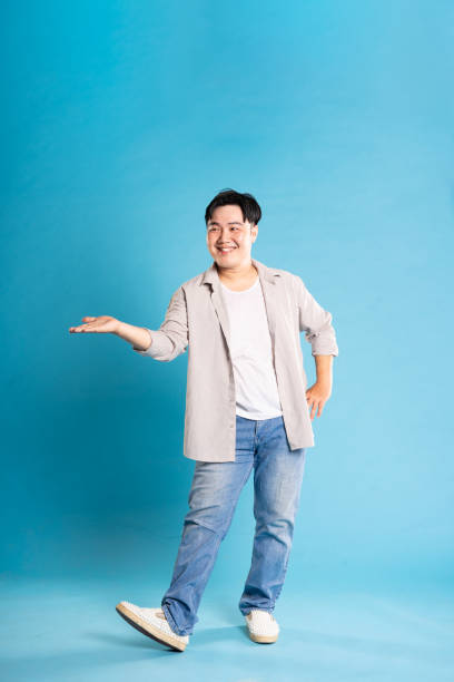istock Full body image of Asian man posing on blue background 1676158452