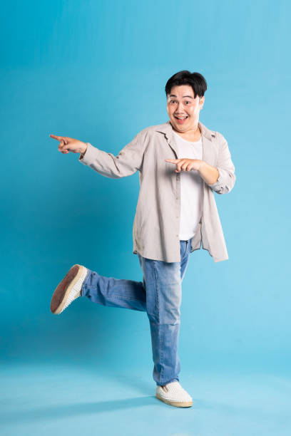 istock Full body image of Asian man posing on blue background 1676159523
