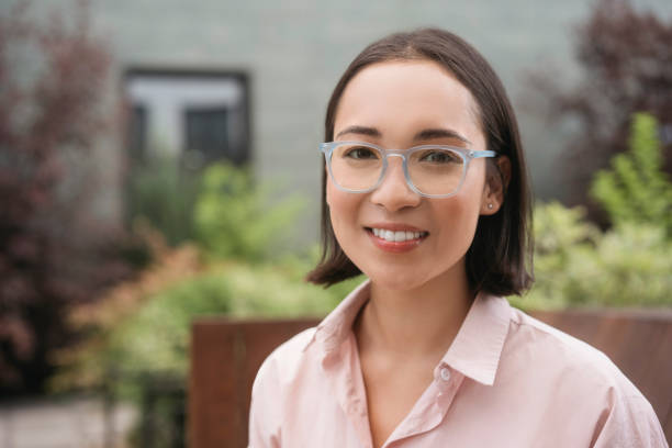 istock Smiling asian student wearing stylish eyeglasses looking at camera in university campus 1676160045