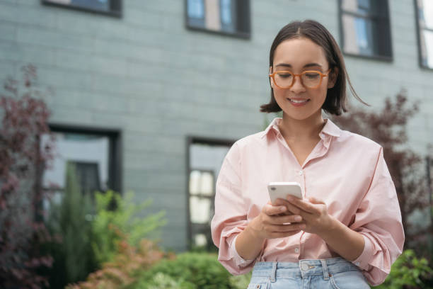 istock Asian woman wearing eyeglasses holding smartphone reading text message, checking email 1676160177