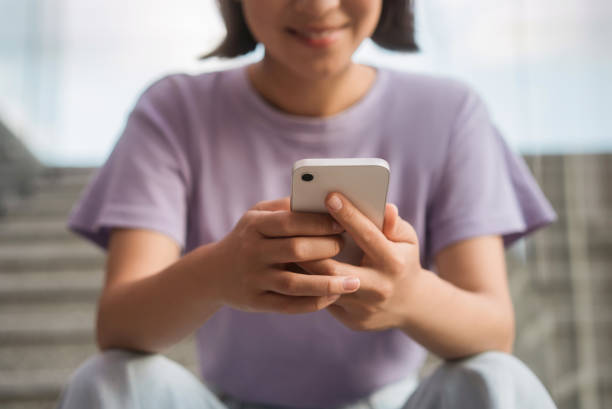 istock Asian woman holding smartphone, reading text message, check email, working online outdoors 1676160980