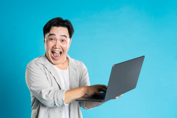 istock Image of Asian man using laptop on blue background 1676171804