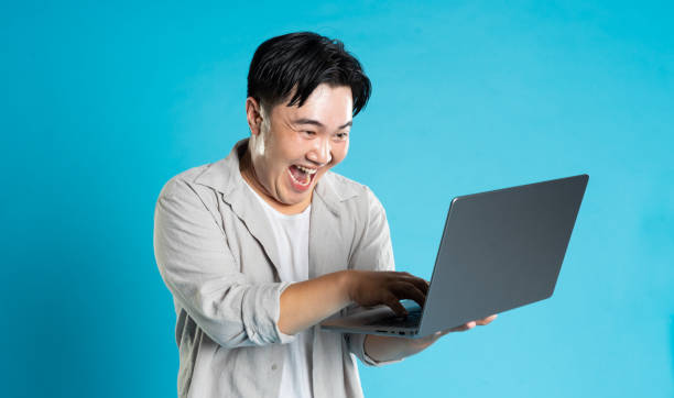 istock Image of Asian man using laptop on blue background 1676171810