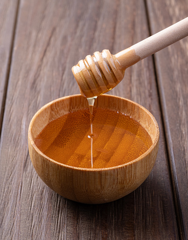 Honey in a tiny bowl with wooden dipper.