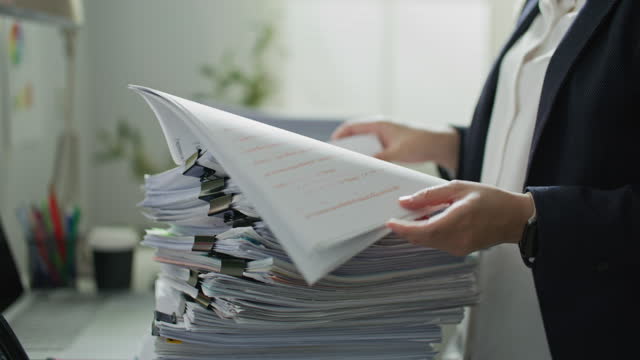 Businesswoman hands working on Stacks of documents files for finance report in office