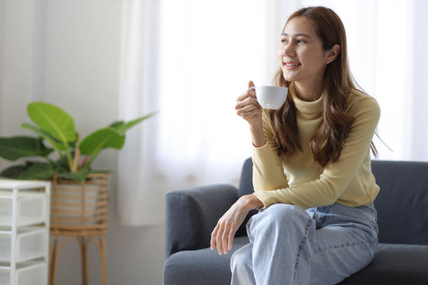 istock Happy Asian woman drinking coffee at home. 1676244203