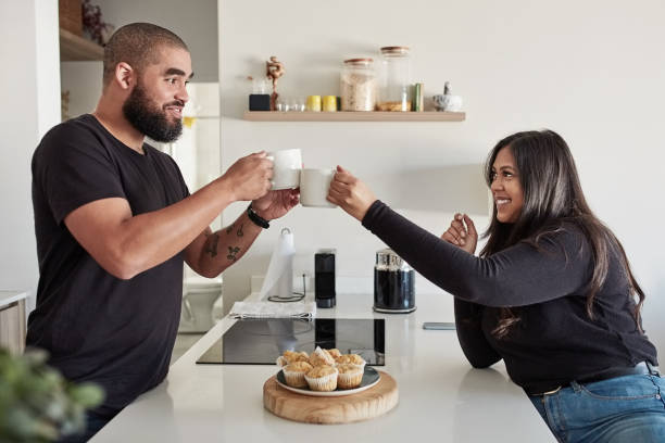 istock Couple, cheers or drinking coffee in home kitchen for morning routine, relax or love support. Mexican man, woman or tea cup toast with breakfast muffins, cupcakes or sweet cakes in house conversation 1676245862