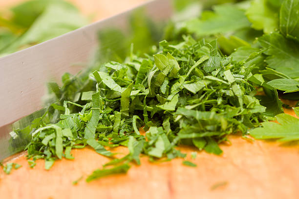 Chopped parsley on wooden cutting board stock photo