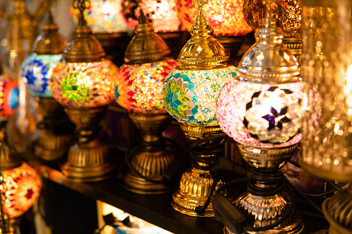 A stand selling very colorful and festive items. All these multicolored candles shine under the light of the lamps.
