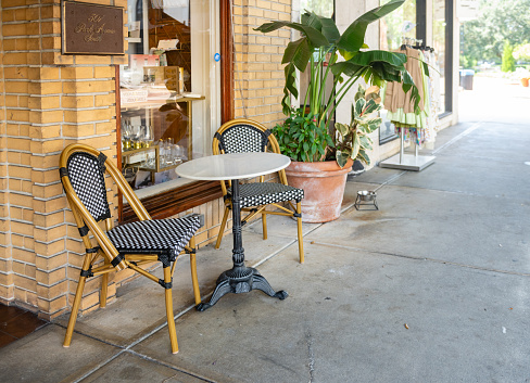 In Winter Park, United States on a hot summer day the cafe chairs and table are empty in the downtown area of the historic Florida neighborhood.