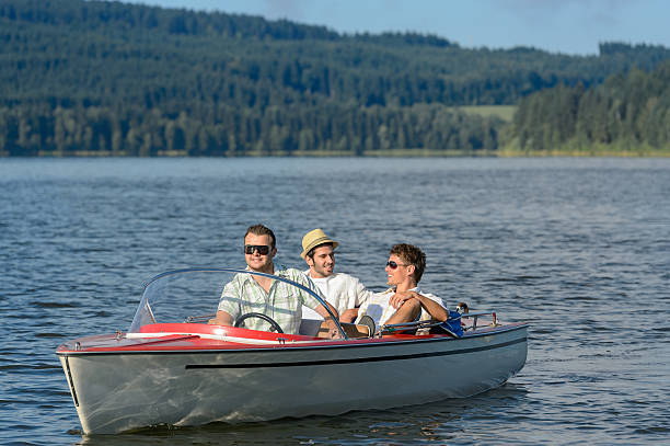 istock Young men sitting in motorboat scenic landscape 167632191