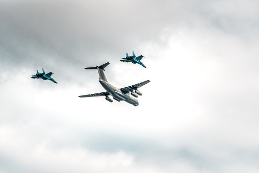 Military planes are flying in the cloudy sky. Transportation theme