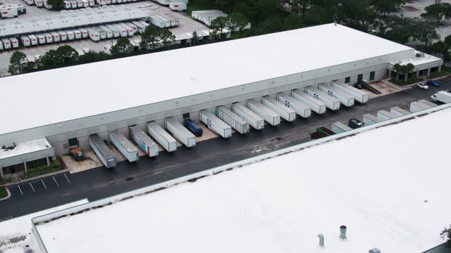 Aerial Drone View of Semi Truck Trailers Parked at a Loading Facility in Orlando Florida on a Gloomy Afternoon Just after a Storm