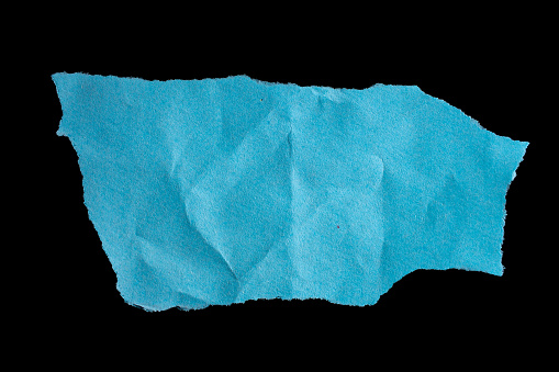 Torn blue paper piece isolated on a black background. Ripped recycled paper texture. Design element.