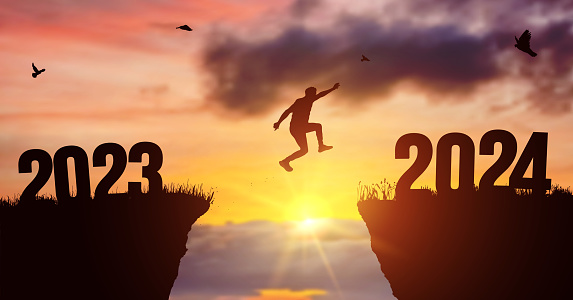 Man silhouette jumping on cliff 2023 over the precipice at amazing sunset. New Year's concept. Vector of starting and welcome happy new year 2024. People enters the year symbol 2024, creative idea.