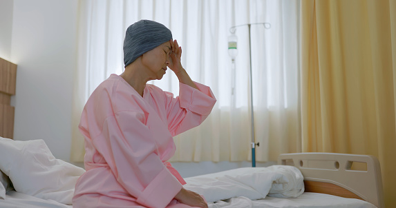 asian worried senior woman sitting on bed feel hopeless about cancer at hospital