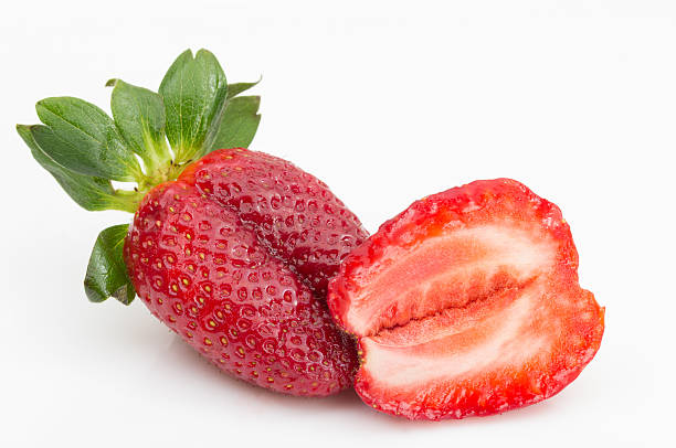 One strawberry and half on white background stock photo