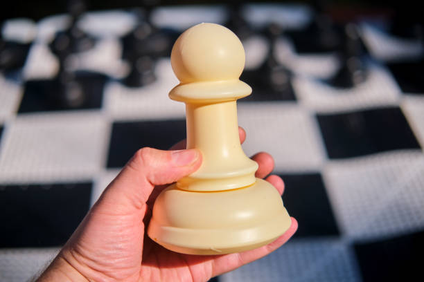 Close-up of a man hand holding a chess piece.