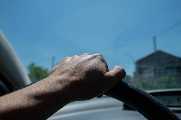 istock Hand of a man driving a car 1676416827