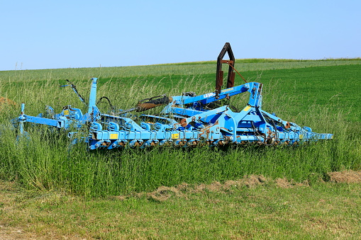 Agricultural equipment has grown into grass