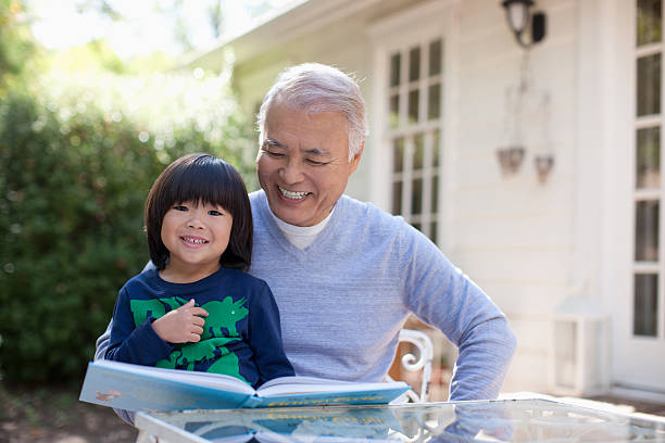 ältere mann und enkel zusammen lesen - grandfather grandson active seniors senior adult stock-fotos und bilder