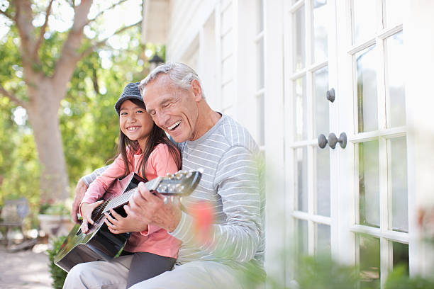 Older man and granddaughter playing guitar  acoustic guitar photos stock pictures, royalty-free photos & images