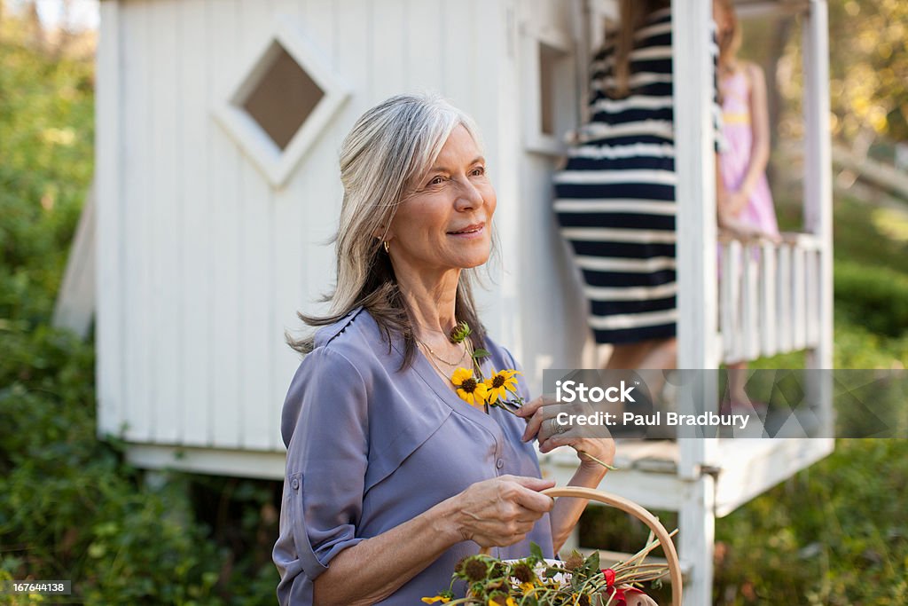 Mujer de edad avanzada luego flores al aire libre - Foto de stock de 30-34 años libre de derechos