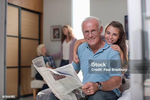 Girl Hugging Grandfather At Home Stock Photo - Download Image Now - Grandmother, Newspaper, Reading